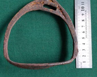 May include: A rusty metal horseshoe with a small hole in the top. The horseshoe is approximately 15 cm in diameter.