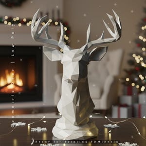 Könnte beinhalten: Eine graue, geometrische Low-Poly-Hirschkopfskulptur. Die Skulptur hat ein facettiertes Design und ein großes Geweih. Der Text "Geometric Deer | Low Poly" befindet sich links und "Ready for Printing FDM | Resin" unten. Die Skulptur steht auf einem Tisch mit Schneeflocken-Dekorationen.