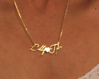 May include: A gold necklace with the names "Lilly" and "Tyler" separated by a heart charm.