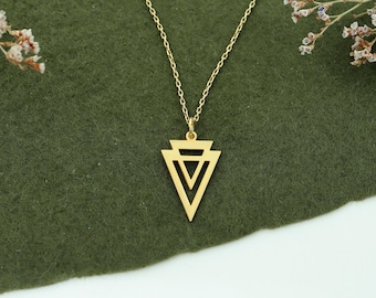May include: A gold necklace with a geometric triangle pendant. The pendant is made of three overlapping triangles.