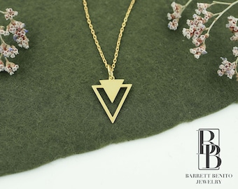 May include: A gold necklace with a geometric triangle pendant. The pendant is made of two overlapping triangles, creating a modern and minimalist design.