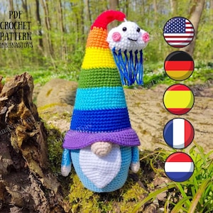 May include: A handmade crochet gnome with a rainbow-striped hat and a white beard. The gnome has a smiling cloud with blue rain hanging from its hat. The text "PDF CROCHET PATTERN ANNANASTOYS" is visible.