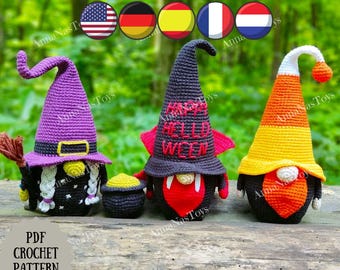 May include: Three crocheted Halloween gnomes. The gnome on the left is wearing a purple witch hat and a black dress. The gnome in the middle is wearing a black hat with a red vampire cape and a red heart. The gnome on the right is wearing a yellow and orange candy corn hat and a black dress. The gnomes are sitting on a wooden surface.  PDF Crochet Pattern ANNANASTOYS