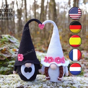 Könnte beinhalten: Ein Häkelmuster für ein Braut- und Bräutigam-Zwergenpaar. Die Braut-Zwergin trägt ein weißes Kleid mit rosa Blumen und einen weißen Hut. Der Bräutigam-Zwerg trägt einen schwarzen Anzug mit einer weißen Fliege und einen schwarzen Hut. Das Muster ist im PDF-Format verfügbar.