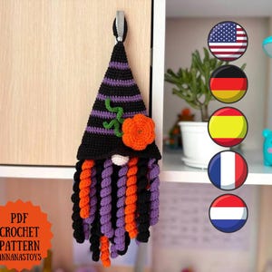 Könnte beinhalten: Ein gehäkelter Wichtel-Wandschmuck mit einer hohen, spitzen Mütze mit schwarzen und violetten Querstreifen, einer leuchtend orangefarbenen Blume und einem langen, lockigen Bart aus schwarzen, orangefarbenen und violetten Garnspiralen. Text: PDF CROCHET PATTERN.
