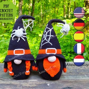 May include: PDF crochet pattern for two Halloween gnomes. One gnome is wearing a black witch hat with a spider and a white spiderweb. The other gnome is wearing a black hat with a white spiderweb. Both gnomes have orange beards and black bodies. The pattern is available for download from AnnaNasToys.