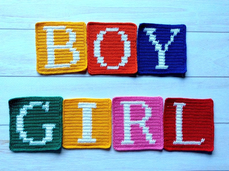 Może przedstawiać: Połączone kwadraty wykonane na szydełku, tworzące słowa "BOY" i "GIRL" białymi literami. Kwadraty są w r&oacute;żnych kolorach: ż&oacute;łtym, pomarańczowym, niebieskim, zielonym, ż&oacute;łtym, r&oacute;żowym i czerwonym.