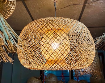 Lampada a sospensione artigianale a forma di ciambella in bambù, paralume intrecciato in stile boho.