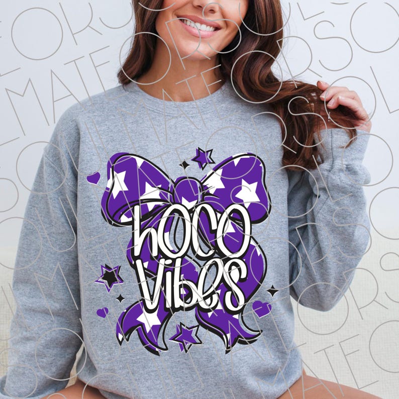 May include: A gray sweatshirt featuring a large purple bow with white stars and a pattern. The bow design includes the words "Hoco Vibes" in white. Small purple hearts and stars are scattered around the bow.