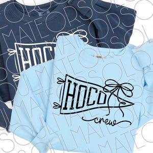 Könnte beinhalten: Zwei langärmlige Sweatshirts, eines in Marineblau und eines in Hellblau. Jedes hat ein Wimpeldesign mit dem Wort "HOCO" in fetten schwarzen Buchstaben und dem Wort "crew" in Schreibschrift. Eine schwarze Schleife und dekorative Elemente vervollständigen das Design.