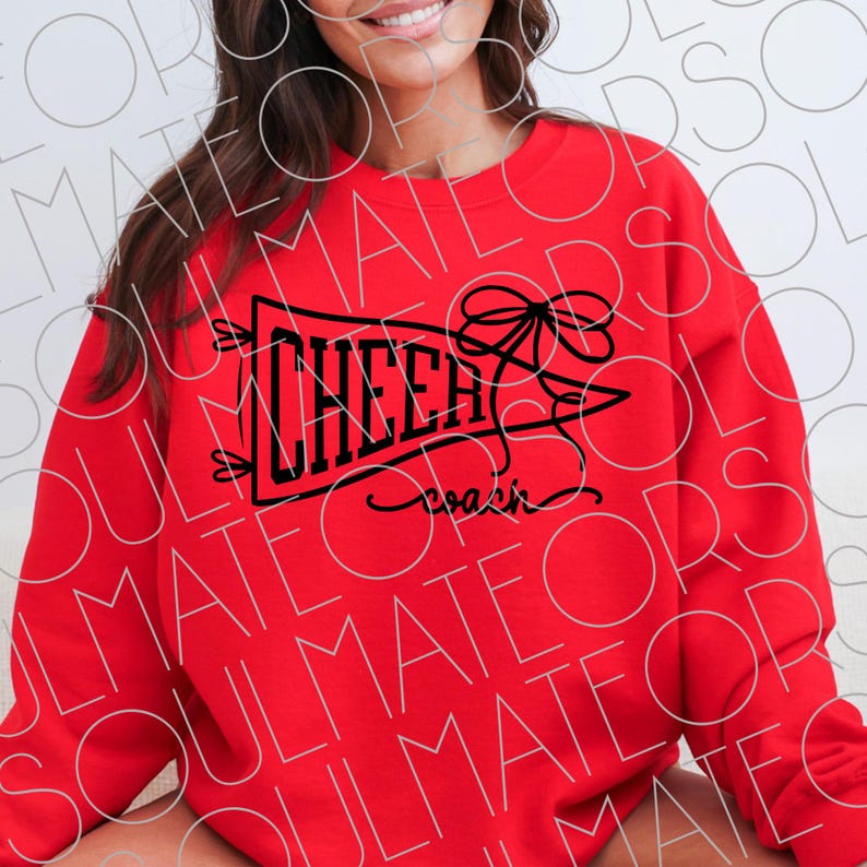 May include: A red sweatshirt with the word "CHEER" in black block letters inside a banner, with a bow and the word "coach" in script. The sweatshirt is a solid red color.