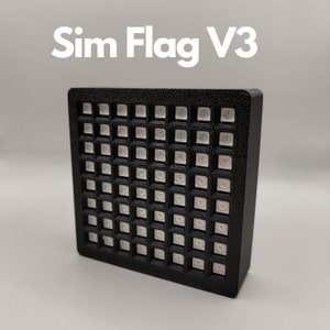 Könnte beinhalten: Ein schwarzes rechteckiges Panel mit einem Raster aus weißen LED-Leuchten. Das Panel ist mit "Sim Flag V3" beschriftet.