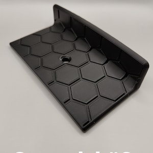 Könnte beinhalten: Schwarzes Gaspedal aus Kunststoff mit einem Wabenmuster und einem kleinen Loch in der Mitte. Gaspedal #2.