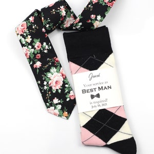 May include: A black and pink patterned tie and socks with a card that says "Jared Your service as BEST MAN is required! July 10, 2021"