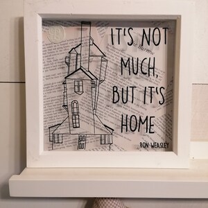 May include: A black and white illustration of a house with a chimney and the text "It's not much, but it's home - Ron Weasley".