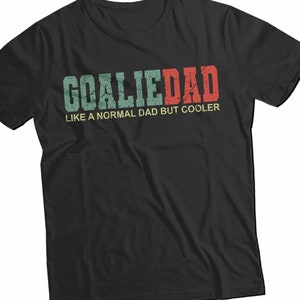 K&ouml;nnte beinhalten: Schwarzes T-Shirt mit einem Vintage-Grafikdruck, auf dem "Goalie Dad Like a Normal Dad But Cooler" steht.