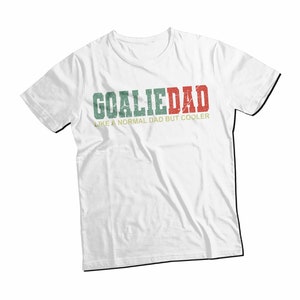 K&ouml;nnte beinhalten: Wei&szlig;es T-Shirt mit einem gr&uuml;n-rot-wei&szlig;en, abgenutzten Aufdruck mit der Aufschrift "Goalie Dad Like a Normal Dad But Cooler".