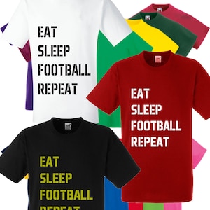 May include: A collection of t-shirts in various colours featuring the text "Eat Sleep Football Repeat" in black and yellow lettering.