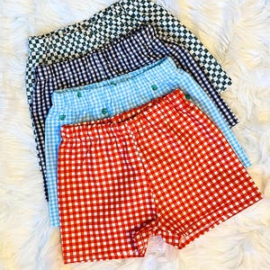 May include: Four pairs of checkered shorts in different colors: red and white, blue and white, navy blue and white, and green and white.