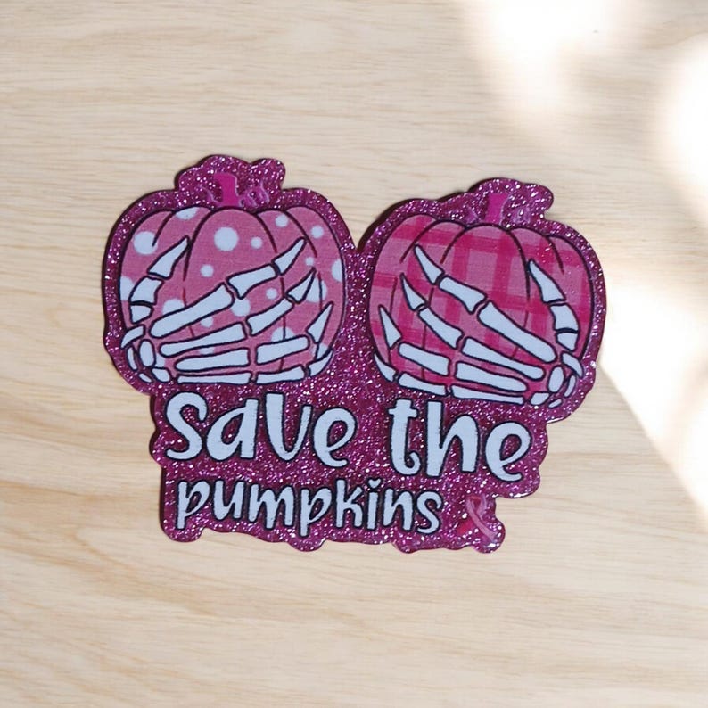 May include: Pink glitter sticker with two pink pumpkins with white skeleton hands and the text "Save the pumpkins" with a pink ribbon.