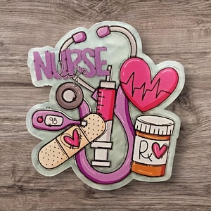 Puede incluir: Una pegatina decorativa con símbolos médicos y el texto "NURSE life". El diseño incluye un estetoscopio, una jeringa, un corazón con una línea de latidos, un termómetro, una venda y un frasco de medicamentos, en tonos rosas y morados.
