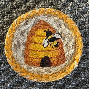 Set of four braided jute coasters, measuring 5” round, includes a woven jute basket. Loon coasters, rooster coasters, pineapple coasters
