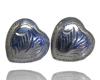May include: A pair of silver heart-shaped earrings with a delicate etched design.