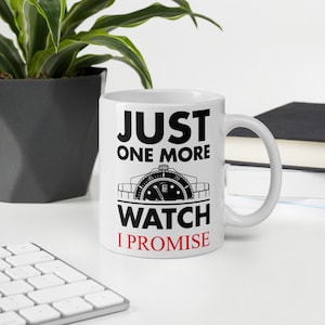 May include: White ceramic mug with a black and white design. The mug features a watch with the text "Just One More Watch I Promise".
