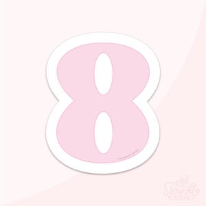 以下が含まれることがあります： 白縁取りの薄いピンク色の数字8のステッカー。数字は丸みを帯びたフォントで、内側は白です。The Sprinkle Factoryのロゴが右下にあります。