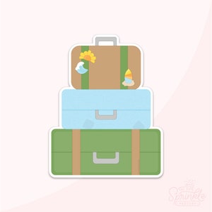 May include: Three stacked suitcases with brown, blue, and green exteriors. The top suitcase has a yellow sun, a blue wave, and a yellow sailboat sticker.
