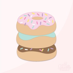 Puede incluir: Una pila de tres donuts con glaseado rosa, azul y chocolate. El donut superior tiene glaseado rosa con chispas de colores. El donut del medio tiene glaseado azul. El donut inferior tiene glaseado de chocolate con chispas marrones.