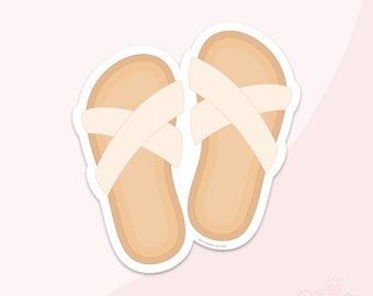 May include: A pair of beige sandals with white straps that cross over the top of the foot. The sandals are on a white background.