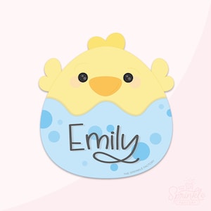 Peut inclure: Un motif en forme de poussin jaune et bleu clair avec le nom "Emily" en écriture cursive. Le poussin a des yeux noirs et un bec orange. Le motif comprend des pois bleus et le texte "THE SPRINKLE FACTORY".