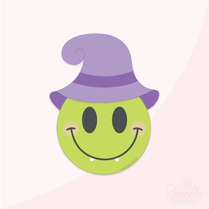 Puede incluir: Una cara sonriente verde con un sombrero de bruja morado. La cara sonriente tiene una amplia sonrisa con dos pequeños colmillos. El sombrero tiene una banda morada alrededor.