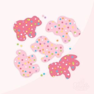 May include: Five pink sugar cookies with colorful sprinkles in the shapes of a bear, a camel, a dog, a bunny, and a bird. The cookies are on a pink background with a white border.