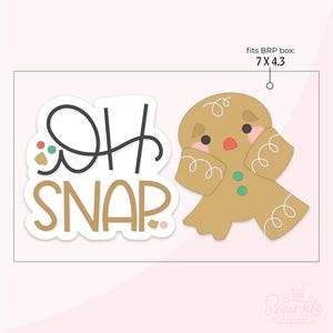 May include: A gingerbread man cookie cutter with the text "Oh Snap" in black and gold. The gingerbread man is light brown with pink cheeks and green buttons. The cutter fits a 7 x 4.3 inch box.