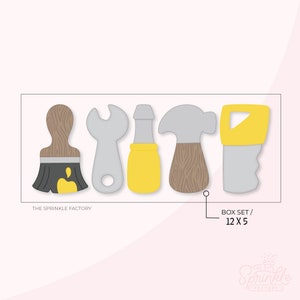 Può includere: Set di cinque stampini per biscotti a forma di utensili: un pennello, una chiave inglese, un cacciavite, un martello e una sega. Gli stampini sono grigi, gialli e marroni. Il testo "THE SPRINKLE FACTORY" e "BOX SET / 12 X 5" è visibile.