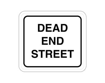 May include: A square white sign with rounded corners featuring a thick black border. The text DEAD END STREET is printed in bold, black, sans-serif capital letters in the center of the sign, clearly indicating a road that does not continue.
