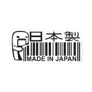 Puede incluir: Una pegatina en blanco y negro que muestra un personaje de dibujos animados estilizado con una boca dentada junto a un código de barras. El texto "日本製" y "MADE IN JAPAN" aparece en letras negras negritas. Diseño rectangular.