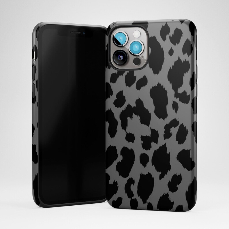 May include: A smartphone and a phone case. The phone case has a gray background with a black leopard print pattern. The smartphone is black and has a black screen.