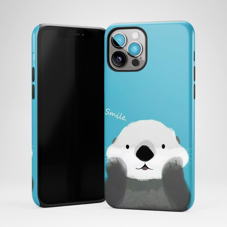 May include: A blue phone case with a cartoon sea otter smiling and the word "Smile." printed on it.