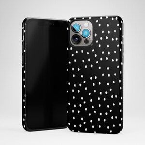 May include: Black phone case with a white polka dot pattern. The case has a cutout for the camera lens.