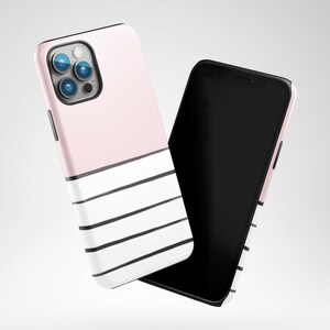 May include: A pink and white phone case with black stripes. The case is designed for a smartphone with a triple lens camera.