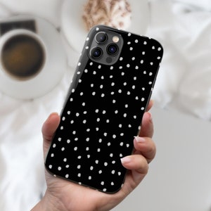 May include: A black phone case with a white polka dot pattern. The case has a camera lens cutout in the upper left corner.