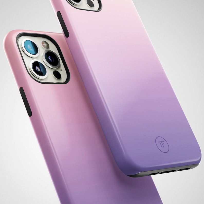 May include: Two phone cases with a gradient design. The top case is a light purple to dark purple gradient. The bottom case is a light pink to dark purple gradient. Both cases have a black button and a black camera cutout. The top case has a small circle with the letters "TF" in the center.