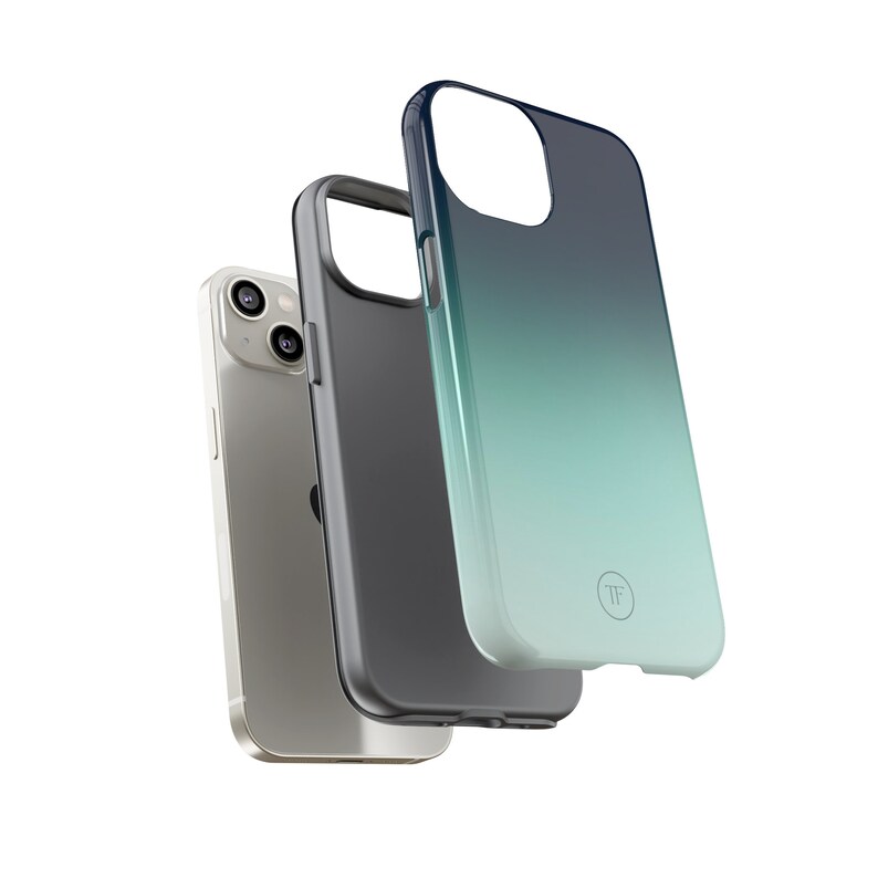 May include: A set of three phone cases for an iPhone. The cases are black, gray, and a gradient of blue and green. The case with the gradient has a small circle with the letters "TF" in it.