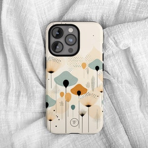 K&ouml;nnte beinhalten: Eine wei&szlig;e Handyh&uuml;lle mit einem schwarzen Kameraobjektiv und einem Design aus abstrakten Blumen in Blaut&ouml;nen, Gelb und Orange. Die H&uuml;lle hat ein kleines Logo mit der Aufschrift "TF".