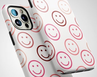 May include: White iPhone case with a pink and red smiley face pattern.