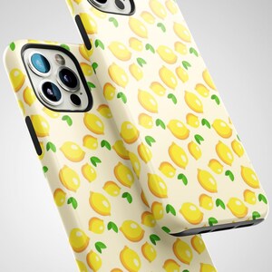 May include: Two iPhone cases featuring a yellow lemon pattern on a white background. The cases are made from hard plastic and have a glossy finish.