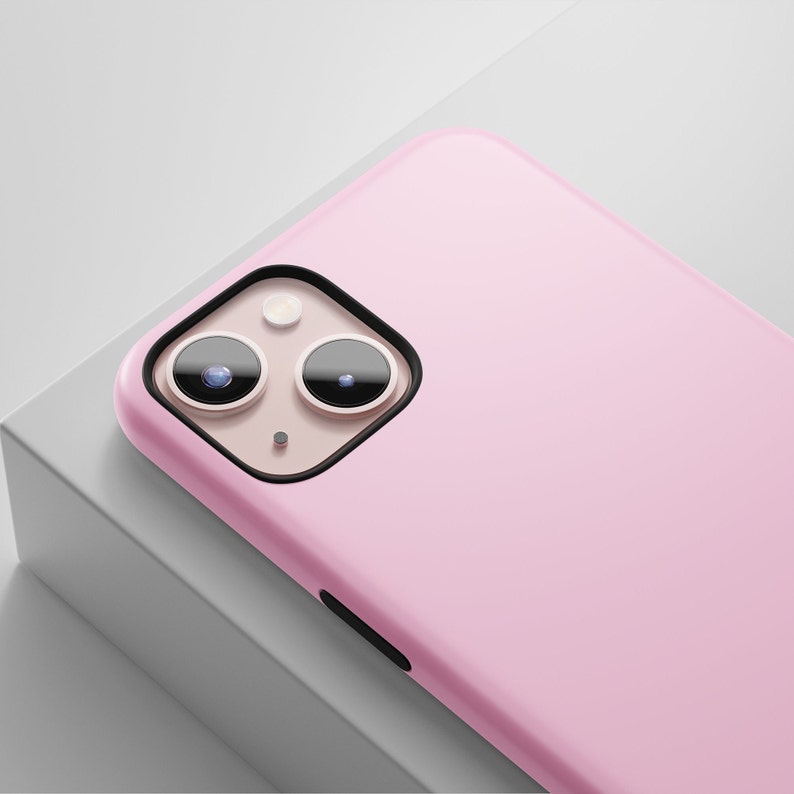 May include: A pink phone case with a black camera cutout and two lenses.